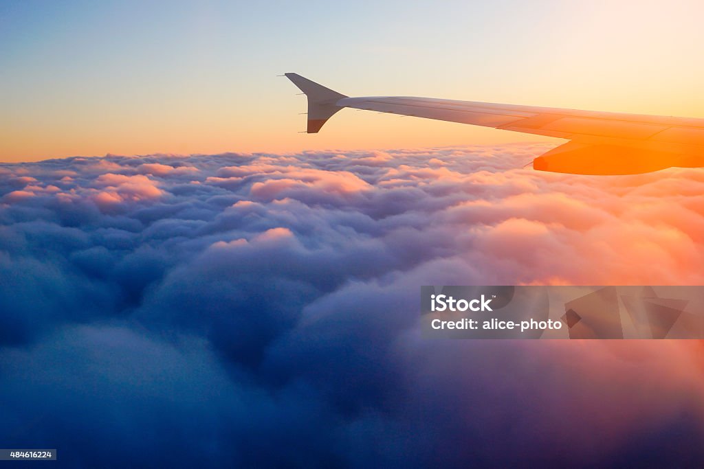 Ala de avión avión en el cielo al atardecer desde la ventana - Foto de stock de Avión libre de derechos