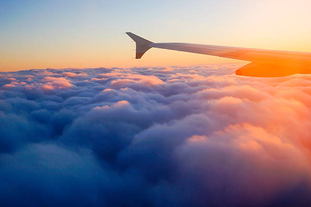 ala de avión avión en el cielo al atardecer desde la ventana - wing airplane sky jet fotografías e imágenes de stock