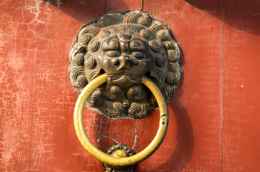 Chinese ancient dragon knocker on a red gate