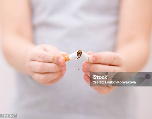 Foto de Jovem Garota É Quebrando O Cigarro e mais fotos de stock de Criança - Criança, Placa de Proibido Fumar, Cabelo Castanho