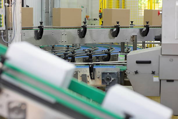 Cardboard boxes on conveyor belts in plant stock photo