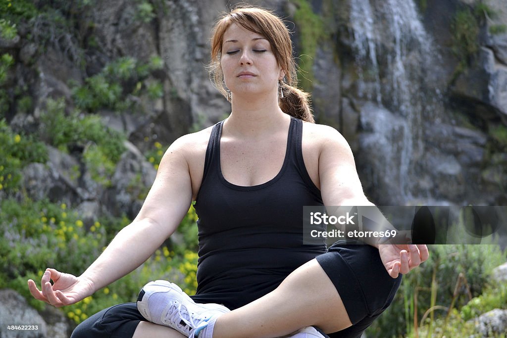 Woman practicing yoga with waterfall background Adult Stock Photo