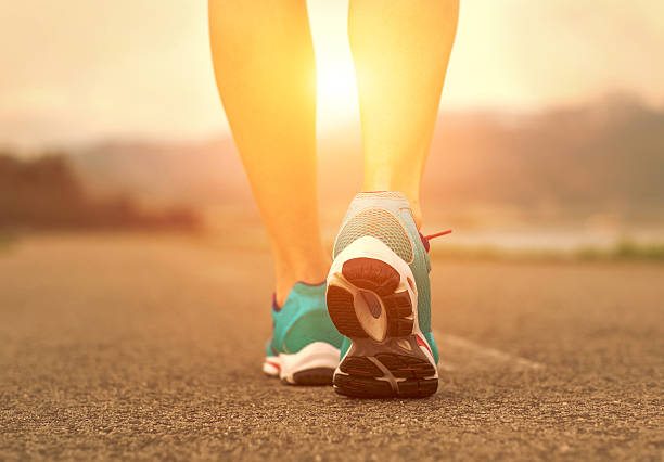 istock Runner athlete feet running on road under sunlight. 484623562