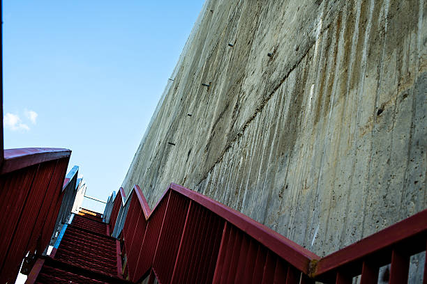 металлические лестнице на серые бетонная стена - concrete wall railing metal bannister стоковые фото и изображения