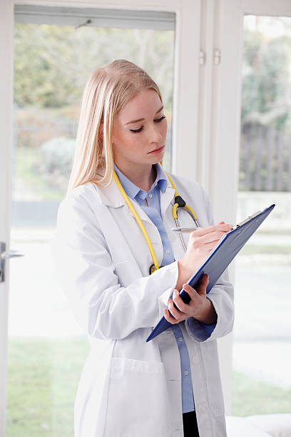 istock Beautiful young doctor holding clipboard 484624053