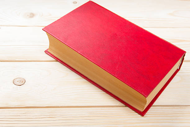 istock Blank red book on wooden table. 484625602