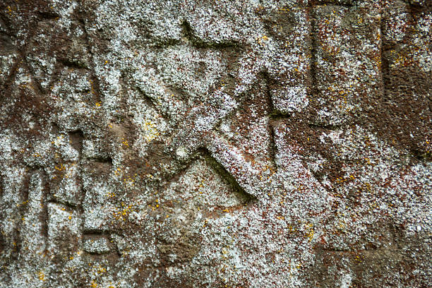 istock Moss-grown surface of the old stone cross 484628876