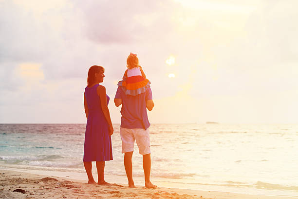 istock romantic couple with little child at sunset tropical beach 484630752