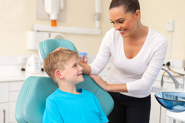 istock young woman talking to her son in dentist office 484633200