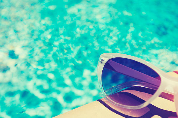 istock Suglasses beside a swimming pool 484638380