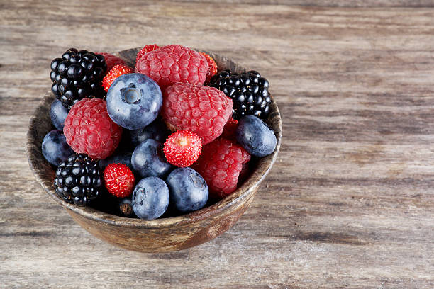 istock Assorted berries in bowl on wood 484639674