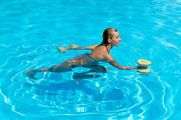 aquagym, de femme dans l'eau avec haltères - water aerobics swimming pool exercising sport photos et images de collection