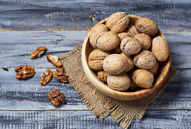 istock Walnuts in old wooden bowl 484649220