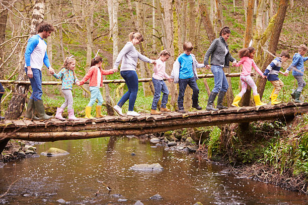 Adults With Children On Bridge At Outdoor Activity Centre stock photo