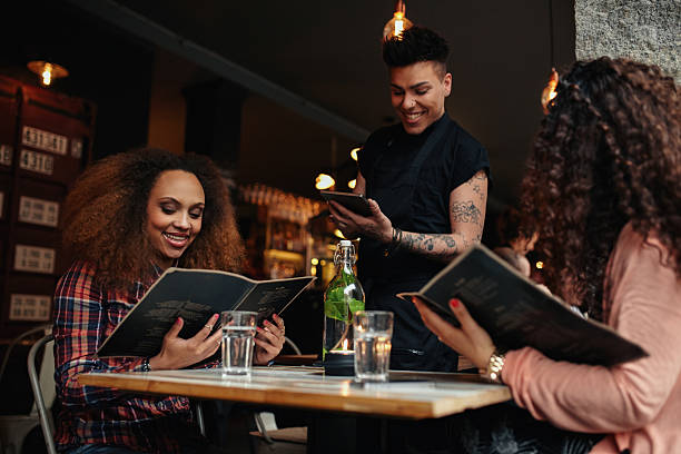 jeunes filles au café pour pouvoir le serveur - menu photos et images de collection