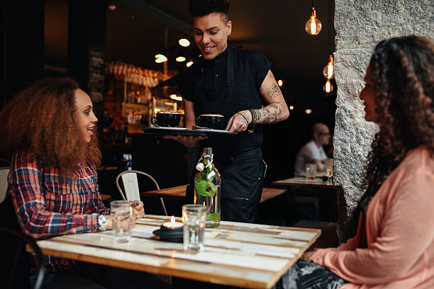 istock Waiter serving coffee to customers at cafe 484650182