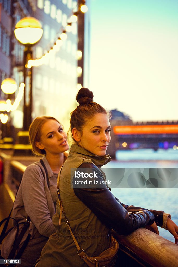 London sightseeing Outdoor portrait of two young women standing at Thames River at the sunset. 20-24 Years Stock Photo
