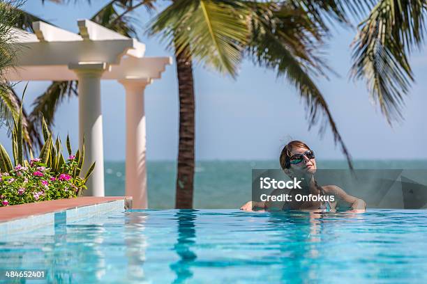 Woman Relaxing Inside Infinity Pool At Tropical Resort Stock Photo - Download Image Now