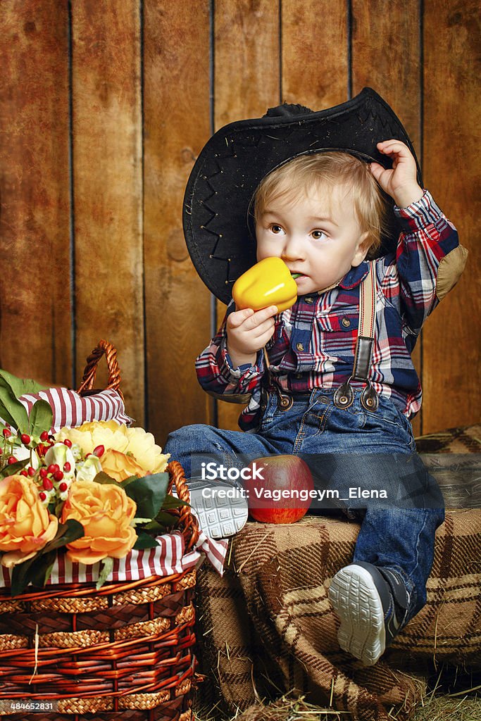 Little cowboy Little Cowboy on a farm in a hat and jeans after harvest Agriculture Stock Photo