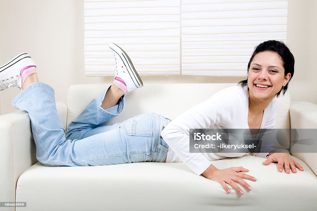 Donna sdraiata su un divano - Foto stock royalty-free di Adulto