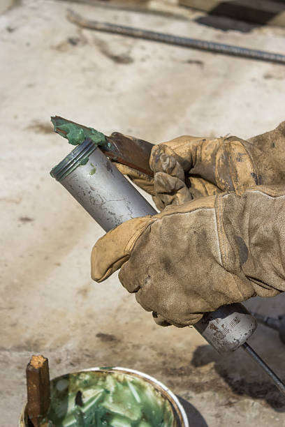 mano de un workman llenado pistola de engrase 2 - lubrication nipple fotografías e imágenes de stock
