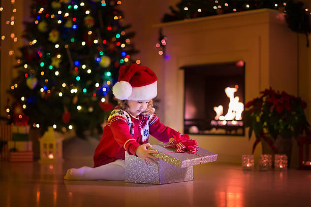istock Kids opening Christmas presents at fireplace 484659118