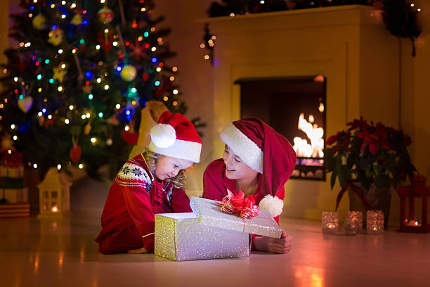 istock Kids opening Christmas presents at fireplace 484659240