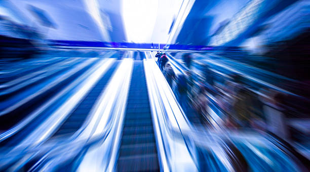 istock escalator on train station, view in blue tone.motion blur 484664860