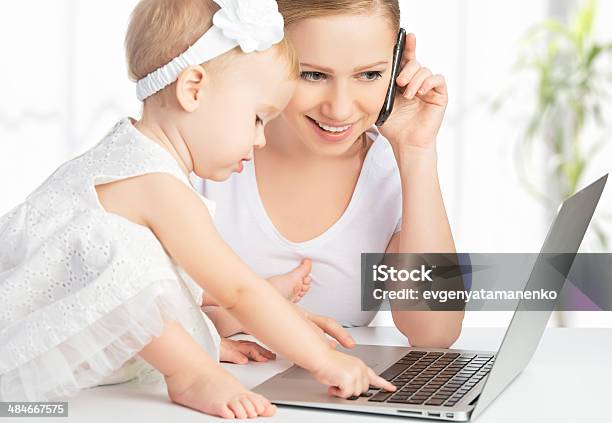 Madre E Hija Bebé Trabaja Con Ordenador Teléfono Foto de stock y más banco de imágenes de Ordenador - Ordenador, Ocupado, Padres