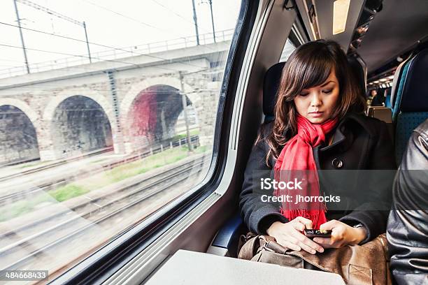 Junge Asiatische Frau Die Mit Dem Zug Stockfoto und mehr Bilder von Eisenbahn - Eisenbahn, Schweiz, Handy