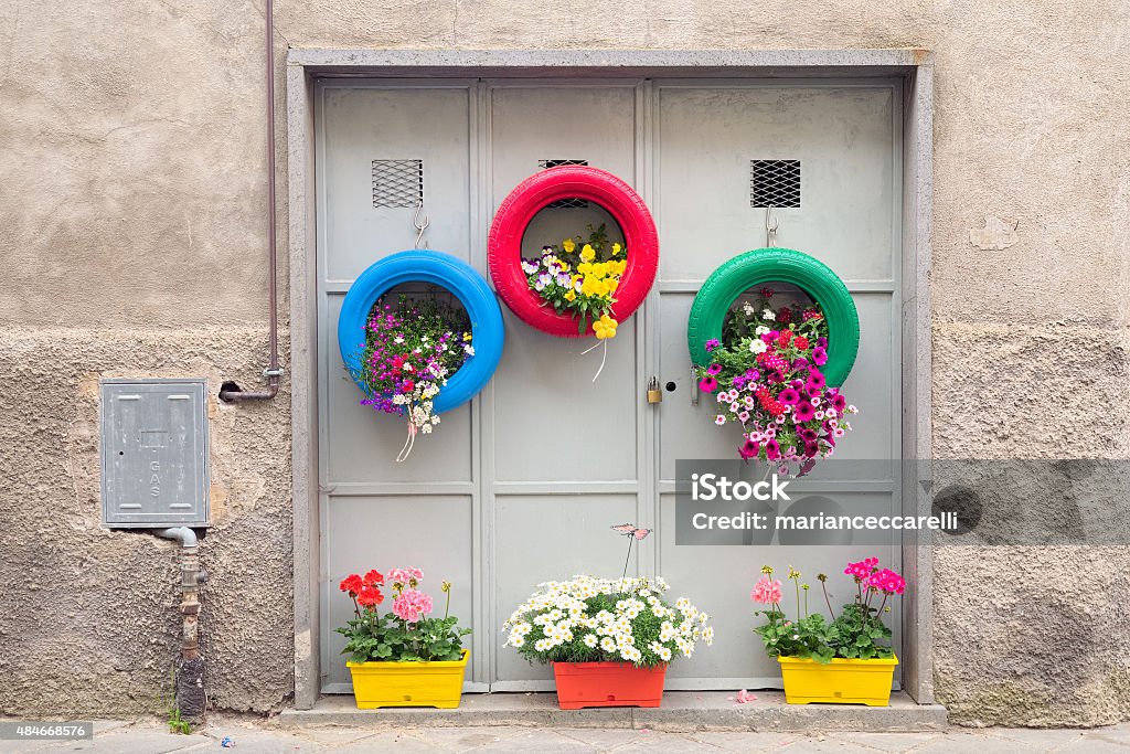 Ingenious, original and environmentally method of recycling Ingenious, original and environmentally friendly method of recycling of tires car as planters in a village in Tuscany Tire - Vehicle Part Stock Photo