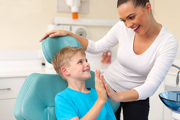 istock little boy and mother high five in dentist office 484669684