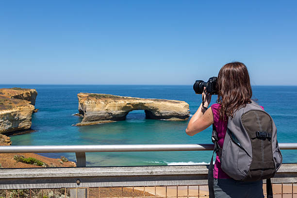 donna fotografo assunzione di foto con fotocamere dslr sulla spiaggia - australia photographing camera beach foto e immagini stock