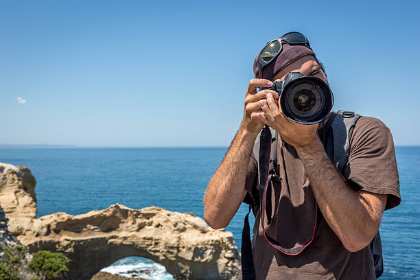 男性カメラマンの中に、デジタル一眼レフカメラで写真のビーチ - australia photographing camera beach ストックフォトと画像
