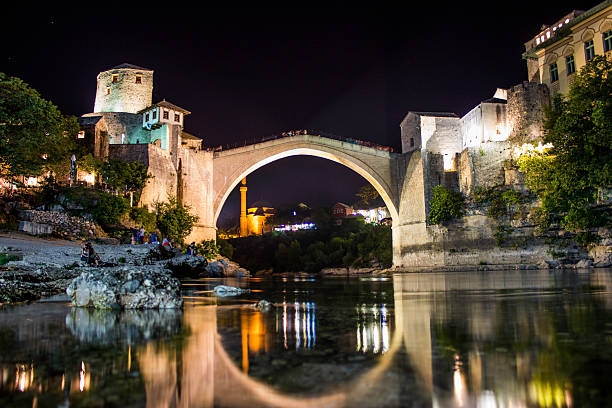 The bridge spans the Neretva river in the old town of Mostar, the city to which it gave the name. The city is the fifth-largest in the country; it is the center of the Herzegovina-Neretva Canton of the Federation of Bosnia and Herzegovina, and the unofficial capital of Herzegovina. The Stari Most is hump-backed, 4 metres (13 ft 1 in) wide and 30 metres (98 ft 5 in) long, and dominates the river from a height of 24 m (78 ft 9 in). Two fortified towers protect it: the Halebija tower on the northeast and the Tara tower on the southwest, called \