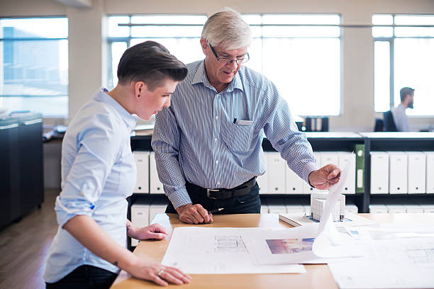 istock Business people analysing blueprints at desk 484674636