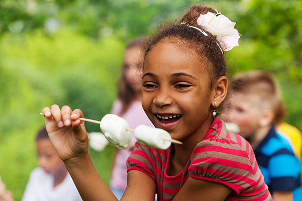 istock Happy African girl holding stick with marshmallow 484674986