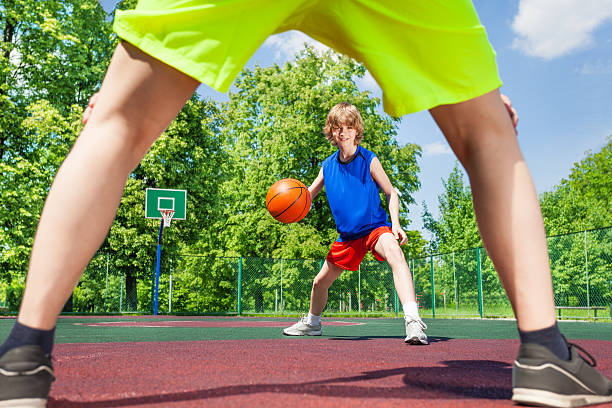 istock View between two legs of player and boy with ball 484675600