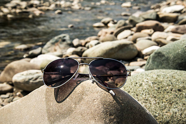 istock Sunglasses on the sea rocks 484676502