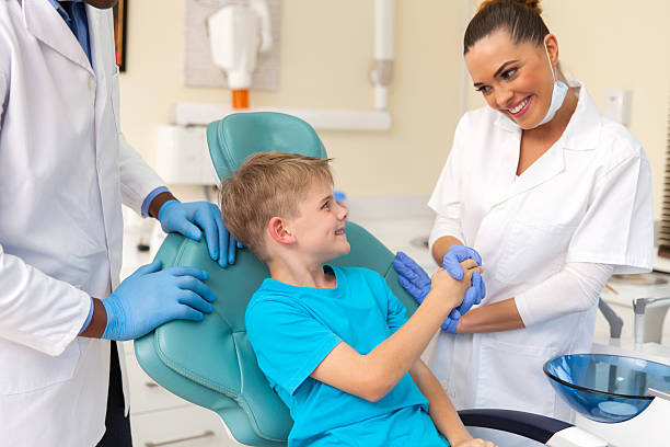 istock female dental assistant greeting little patient 484677662