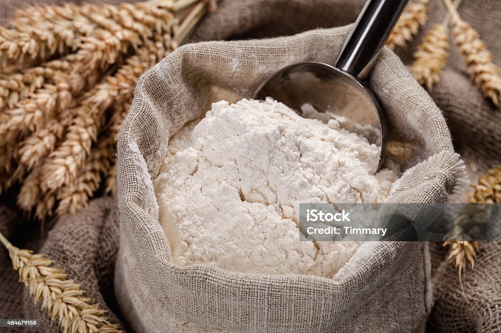 Flour in a bag on the table and spikelets Flour in a bag on the table and spikelets. Flour Stock Photo