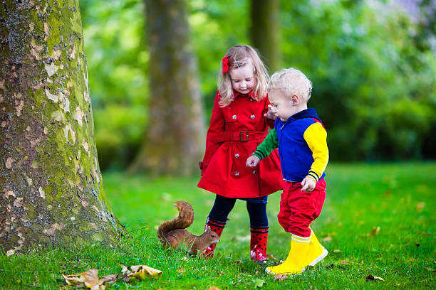 istock Kids feeding squirrel in autumn park 484679188