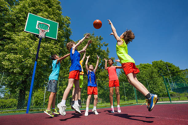 istock Teens in jump playing basketball game together 484680012