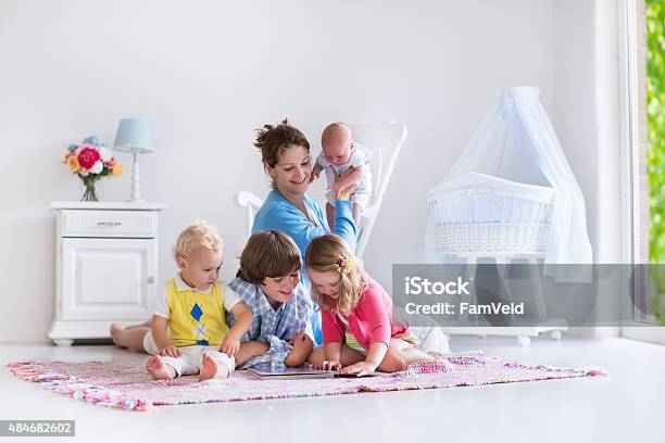 Mother And Kids Playing In Bedroom Stock Photo - Download Image Now - Newborn, Rocking Cradle, 2015