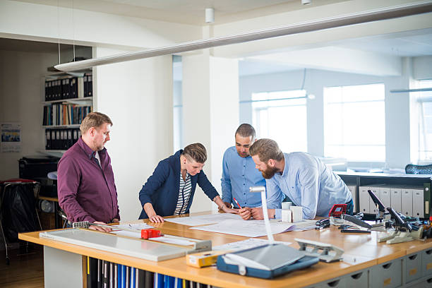 istock Colleagues studying blueprint at desk 484682746