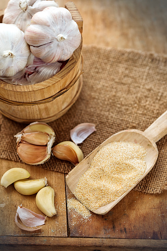 Wooden spoon with dried garlic and fresh onion 