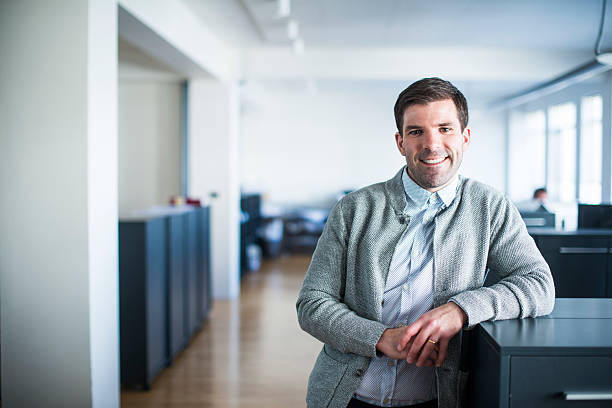 istock Smiling businessman leaning on cubicle in office 484685768