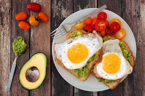 istock Healthy avocado, egg toasts with tomatoes on rustic wood background 484687382