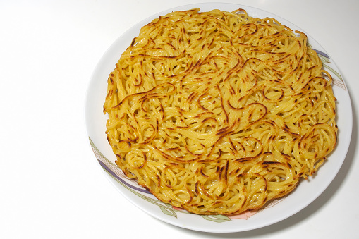 Frittata of pasta with spaghetti, eggs, sea salt and some spices. Italian traditional food.