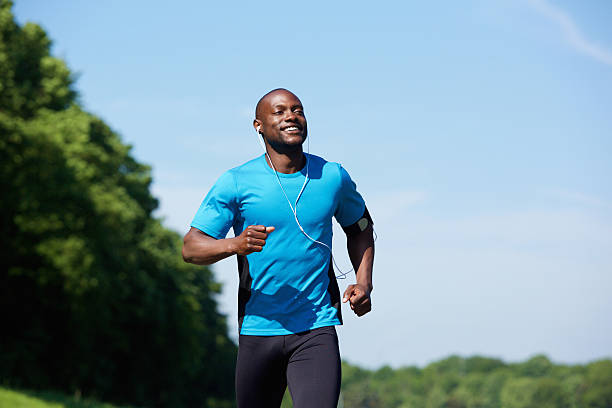 Active african american man running Portrait of an active african american man running exercise workout outdoors running stock pictures, royalty-free photos & images